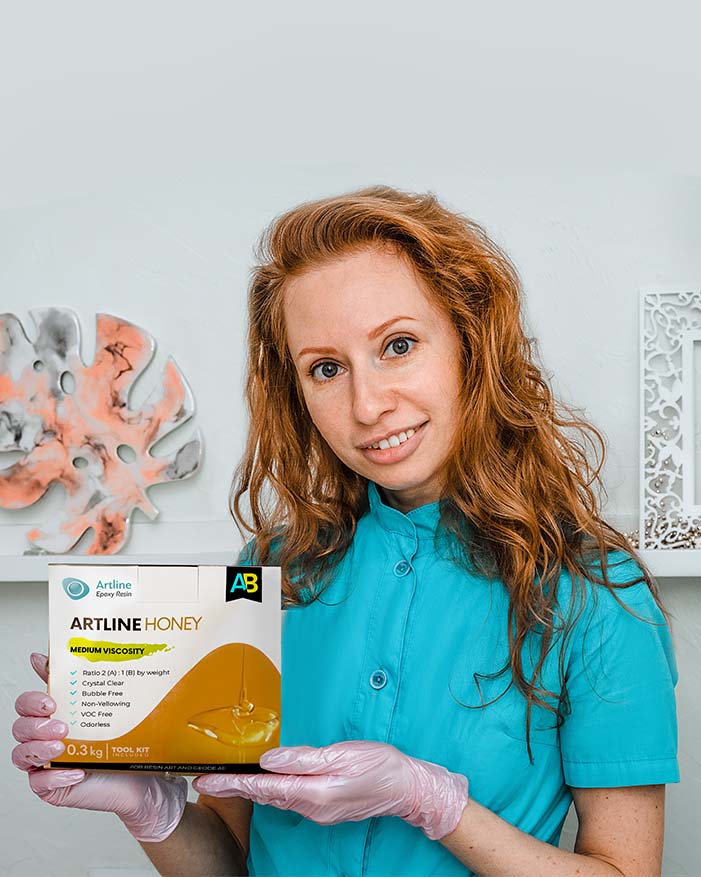Female epoxy resin artist holding Artline Honey Epoxy Resin Kit