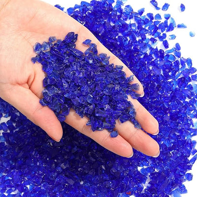 Blue glass chips for craft in hand, 50g pack, ideal for resin and DIY projects.