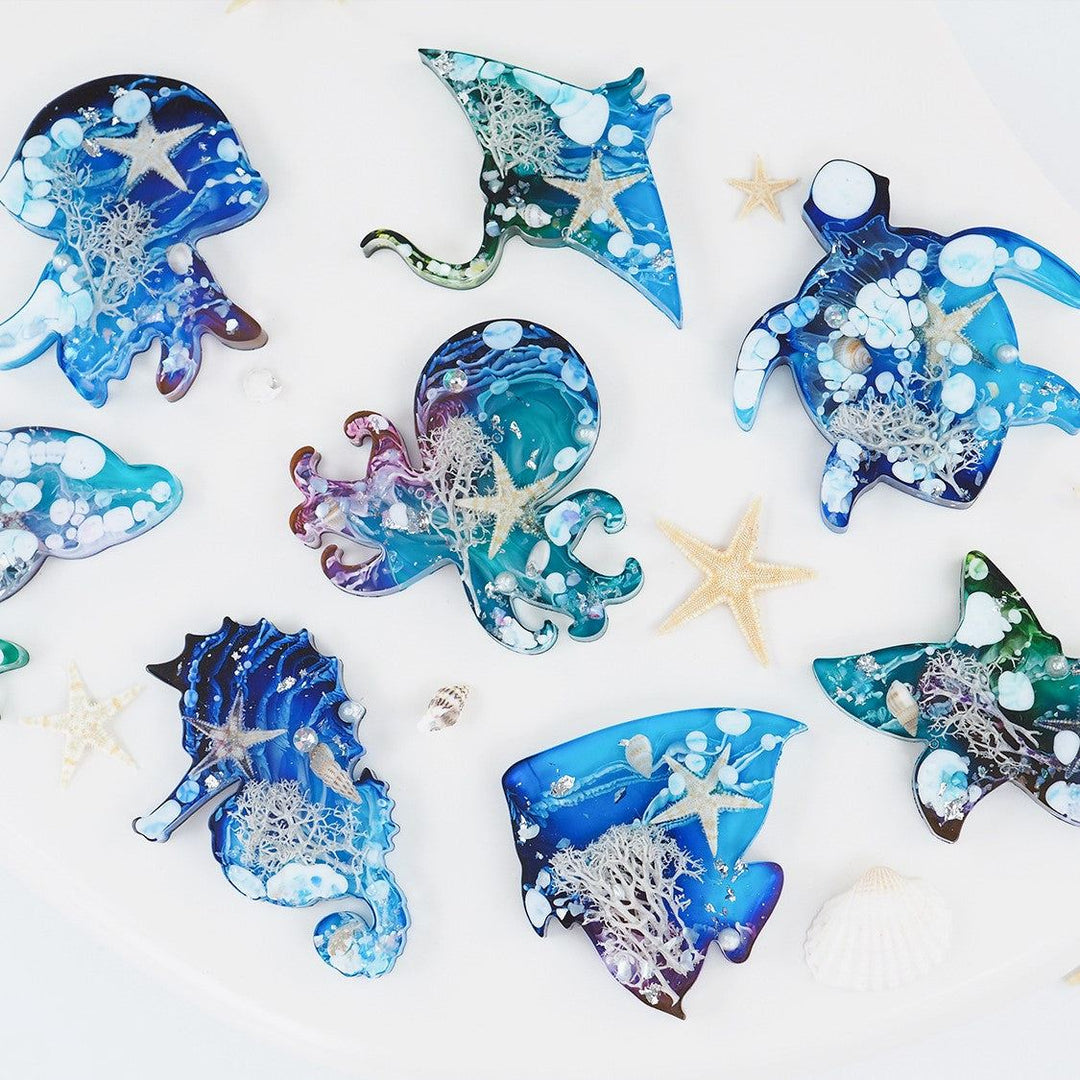 Silicone mold creating ocean animal resin crafts, including sea turtle, dolphin, fish, octopus, jellyfish, starfish, seahorse, and stingray.