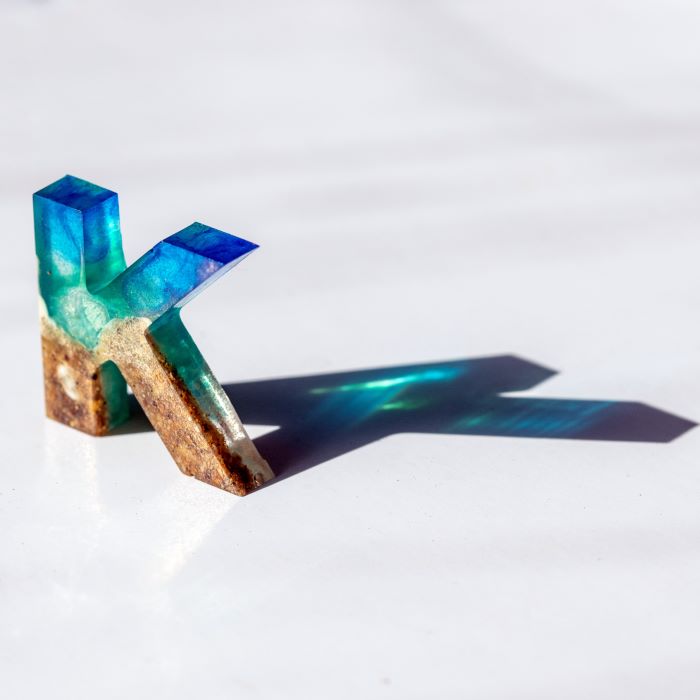 Translucent resin letter 'K' from silicone mold in sunlight.