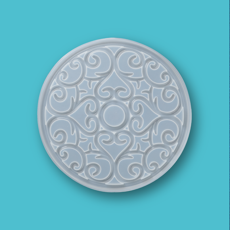 Translucent silicone mold for mandala coaster design on a blue background.